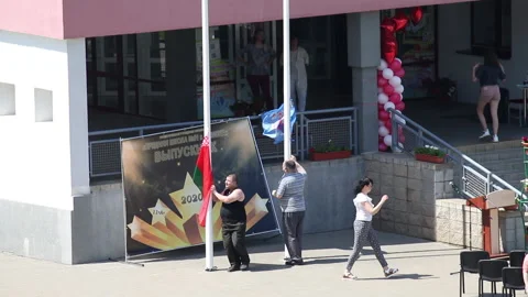 Preparing for the school graduation celebration. Workers raise the flag of th Stock Footage 132413181