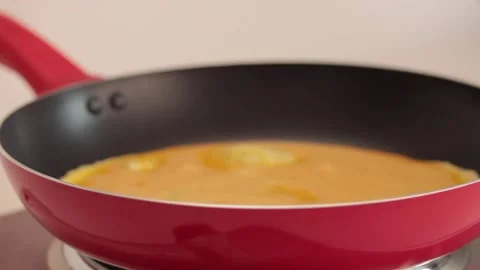 Preparing scrambled eggs in a cooking pan Stock Footage 133814713