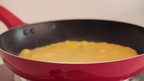 Preparing scrambled eggs in a cooking pan Stock Footage 133814766