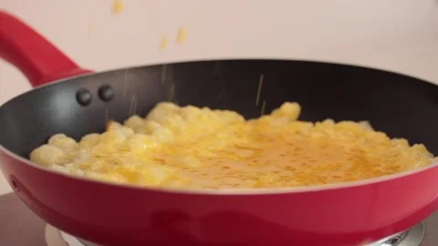 Preparing scrambled eggs in a cooking pan Stock Footage 133814871