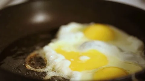 Preparing scrambled eggs on hot frying pan Stockbeeldmateriaal 72202770