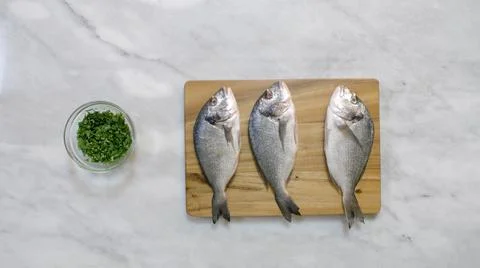 Preparing sea bream: stuffing with coriander and spices Stock Photos