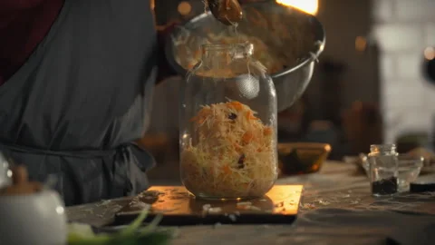 Preparing shredded cabbage for fermentation in a glass jar during a cozy kit 스톡 동영상 331357381
