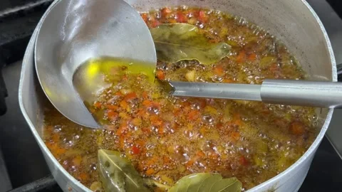 Preparing a simmering sofrito with vegetables and bay leaves Video stock 344100260