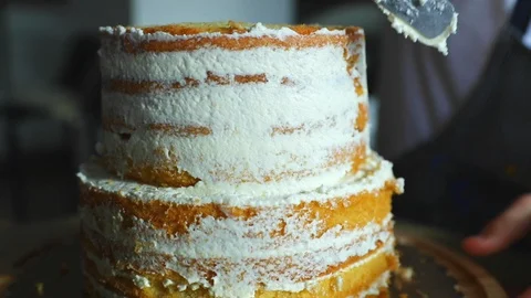 Preparing a simple two-story cake while smearing the cream 스톡 동영상 107644606