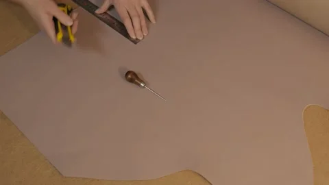 Preparing the skin for work. Marking and cutting of leather. Cut out the details Stock Footage 169285715