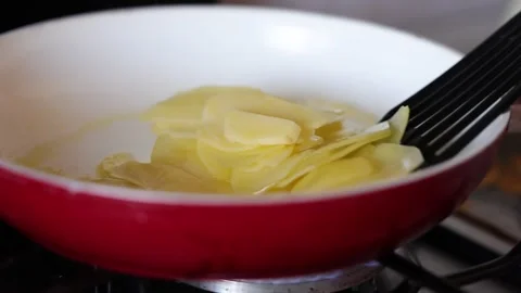 Preparing sliced potatoes in a pan with oil, salt, and rosemary Stock Footage 346034053