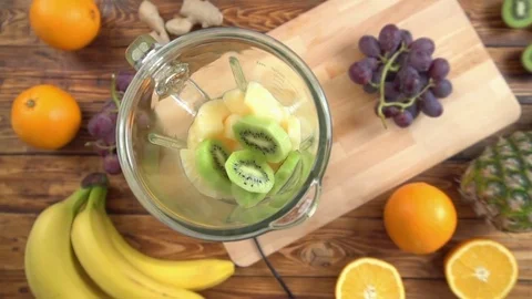 Preparing smoothie in blender surrounded with different fruits Stock Footage 85305311