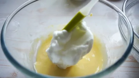Preparing souffle pancakes by mixing egg whites and yolk cream Stock Footage 132507780