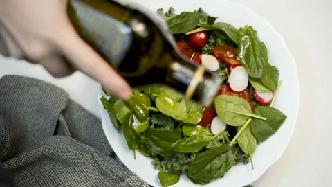 Preparing spinach salad by pouring olive oil. Stock Footage 170313374