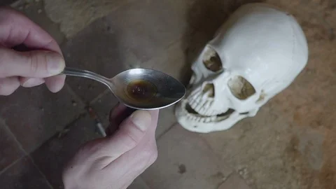 In preparing spoon dose of the drug. skull background. Close up 動画素材 92771925
