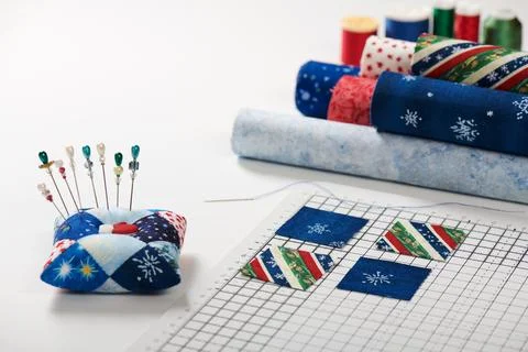 Preparing of square pieces of fabrics for sewing quilt on craft mat, pincus.. 스톡 사진