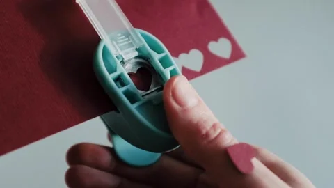 Preparing for St. Valentines Day, making heart shaped paper confetti Stock Footage 326243827