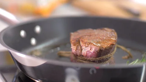 Preparing steak filet mignon with butter and rosemary Видео 106923682