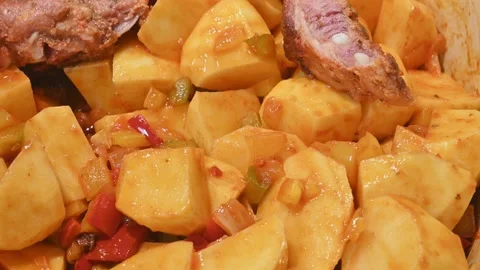 Preparing a stew of roasted ribs, with potatoes and adding the meat Stock Footage 219720637