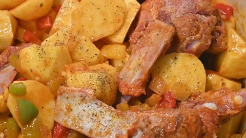 Preparing a stew of roasted ribs, seasoning with pepper Stock Footage 219720620