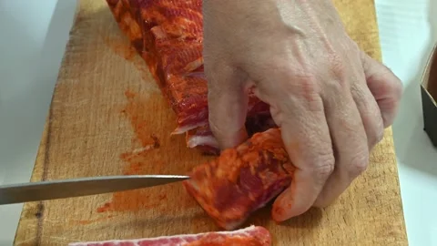 Preparing a stew of roasted ribs, splitting them with a knife Stock Footage 219720438
