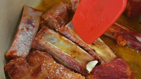 Preparing a stew of roasted ribs, turning them to fry them well Stock Footage 219720364