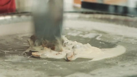 Preparing stir-fried ice cream rolls with chocolate bar at freeze pan. Rolled Stock Footage 111264673