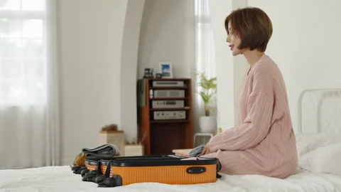 Preparing a suitcase on a bed in a cozy room Stock Footage 300020941