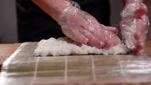 Preparing sushi at home, close-up of the chef's hands distribute rice on a nori Vídeo Stock 151246674