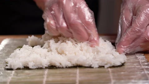 Preparing sushi at home, close-up of the chef's hands distribute rice on a nori Vídeo Stock 151247480