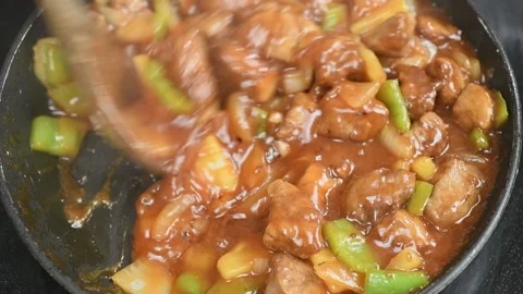 Preparing sweet and sour pork in a frying pan. Video stock 169800532