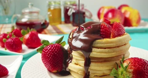 Preparing a sweet dessert, waffles in chocolate with strawberries. Stock Footage 239014633