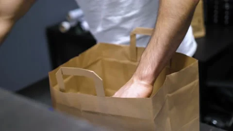 Preparing Take away food to paper back, kraft paper bag ready to ship. 4k video Stock Footage 237875615