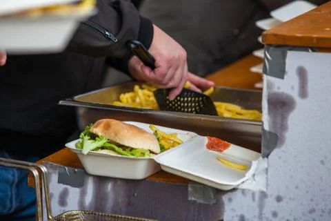 Preparing take away meal portion with freshly cooked burger and french fries  Stock Photos