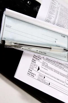 Preparing taxes - check and forms on keyboard Stock Photos
