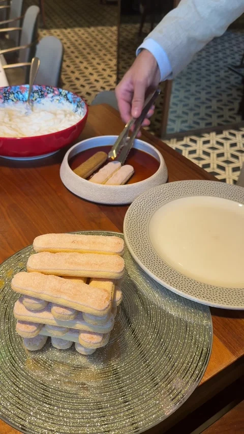Preparing tiramisu dessert by soaking biscuits in liqueur Stock Footage 340581318