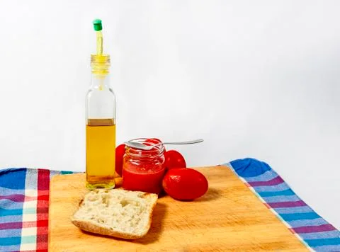 Preparing a toast of good bread, olive oil and tasty tomato juice on a white Stock Photos