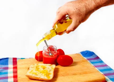 Preparing a toast of good bread, olive oil and tasty tomato juice on a white 写真素材