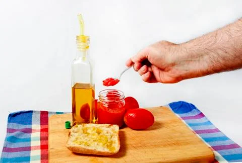 Preparing a toast of good bread, olive oil and tasty tomato juice on a white Stock Photos