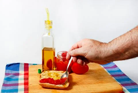 Preparing a toast of good bread, olive oil and tasty tomato juice on a white Stock Photos