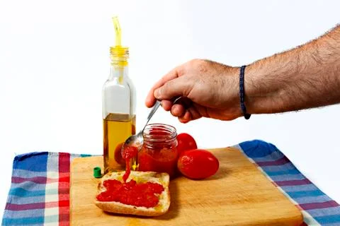 Preparing a toast of good bread, olive oil and tasty tomato juice on a white Stock Photos