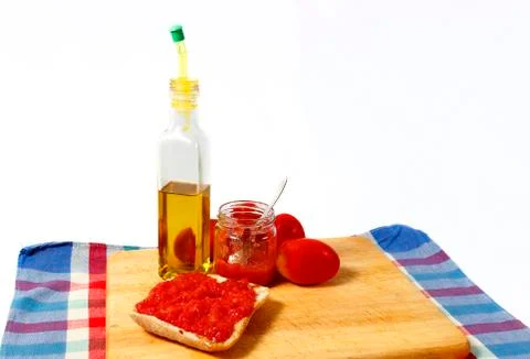 Preparing a toast of good bread, olive oil and tasty tomato juice on a white Foto stock