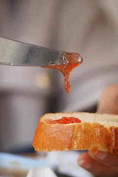 Preparing toast with jam in a kitchen setting during breakfast time Stock Photos