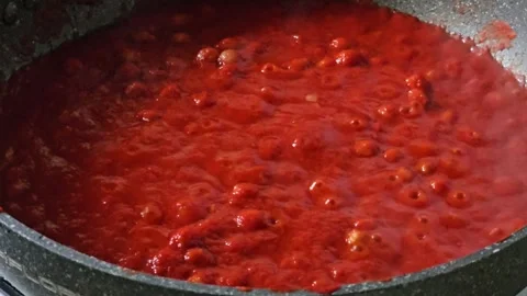 Preparing tomato sauce in a pan, bubbles visible on the surface of the sauce Stock Footage 322007737