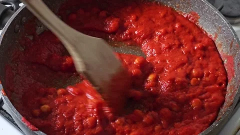 Preparing tomato sauce in a pan, bubbles visible on the surface of the sauce Stock Footage 322007753