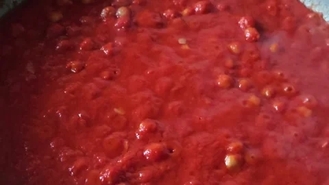 Preparing tomato sauce in a pan, bubbles visible on the surface of the sauce Stock Footage 322007754