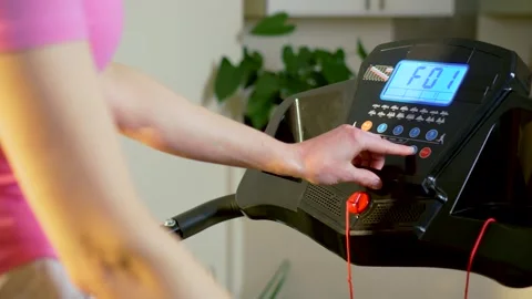 Preparing treadmill workout program on digital console before starting home 動画素材 333245950