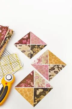 Preparing of triangle pieces of fabrics for sewing quilt blocks, rotary cut.. Fotos de archivo