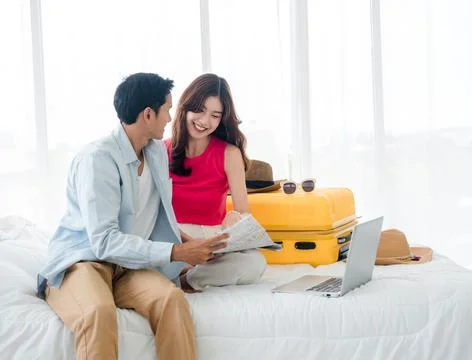 Preparing trip and vacation plan concepts. Young pretty Asian woman and man i Stock Photos