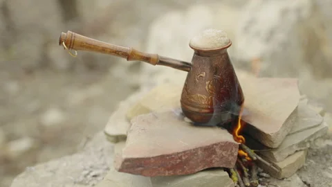 Preparing turkish coffee in a copper cezve over a fire. Boiling coffee Stockbeeldmateriaal 172254019