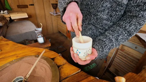 Preparing Turkish coffee in a copper cezve on hot sand is an old Turkish way of Stock Footage 175876879