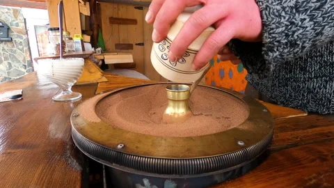 Preparing Turkish coffee in a copper cezve on hot sand is an old Turkish way of Stock Footage 176837669