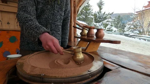 Preparing Turkish coffee in a copper cezve on hot sand is an old Turkish way of Stock Footage 177609658