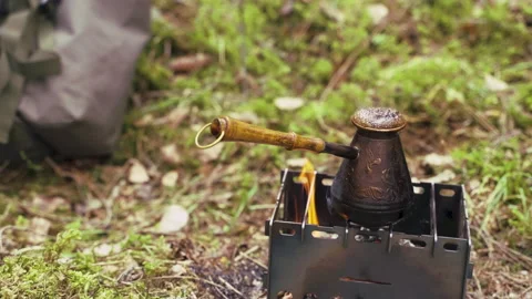 Preparing turkish coffee in a copper cezve over a fire. Boiling coffee cooking Stockbeeldmateriaal 188900309